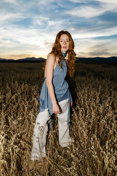 Woman with ginger hair posing in field 