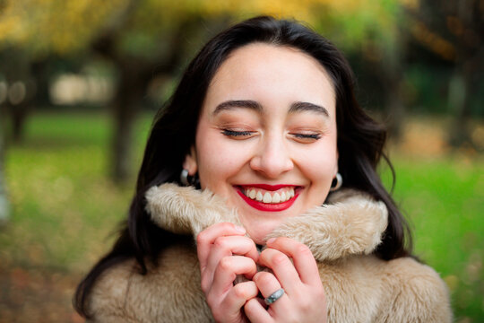 Happy woman with closed eyes wearing warm coat