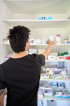 Veterinarian organizing medicine and supplies in clinic pharmacy