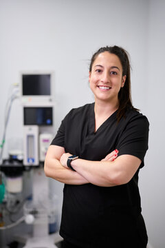 Female veterinarian smiling, standing in animal hospital
