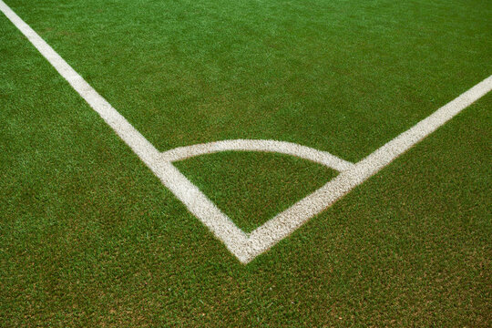 Green soccer field with white corner marking. Sports field for training and competitions. Leisure activity, sports facility, soccer field, recreational activities, sports club.