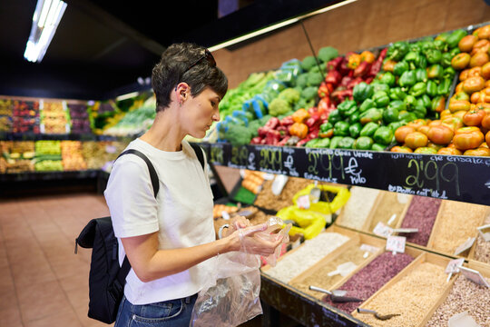 Woman shopping for fresh produce in supermarket aisle