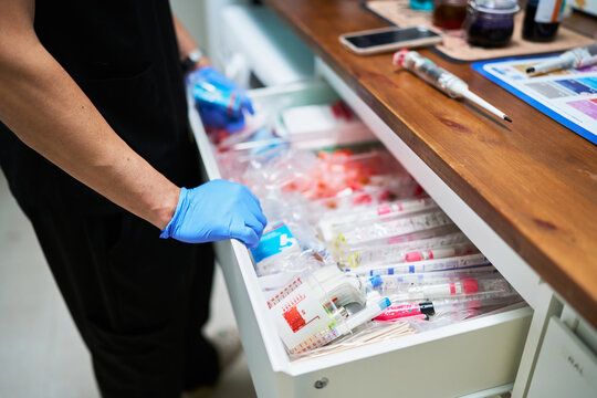 Veterinarian's hand opening drawer with laboratory medical supplies