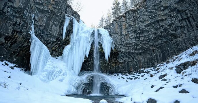 Majestic frozen waterfall in a snowy winter landscape.
