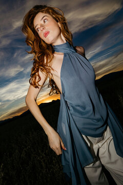 Red-haired woman posing outdoor at sunset