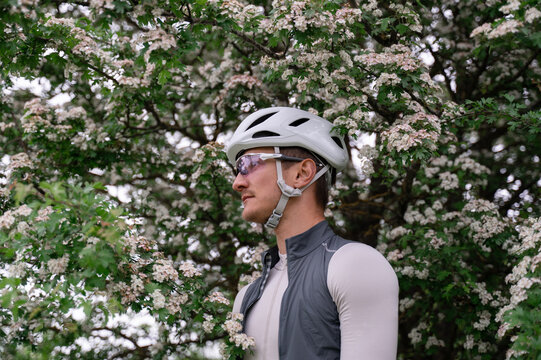 Portrait of a Cyclist Standing Beneath a Blooming Tree