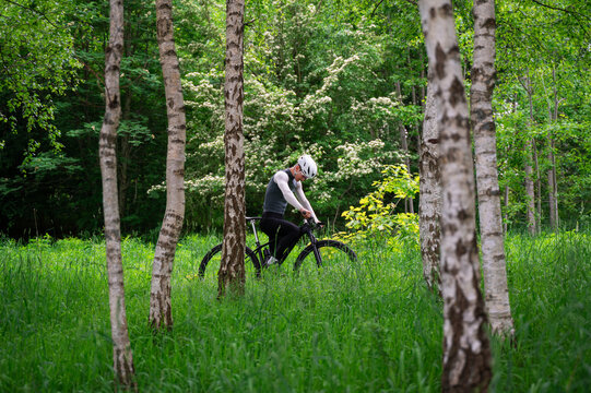Cyclist Resting Along a Forest Trail in Spring