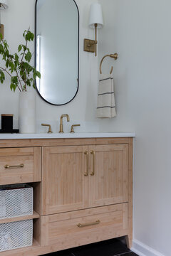 Modern Vanity Bathroom with Brass Fixtures and Oval Mirror