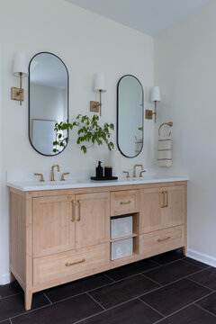 Modern Double Vanity Bathroom with Brass Fixtures and Oval Mirrors