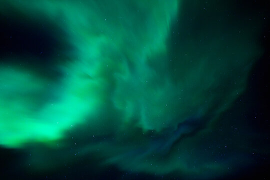Green aurora lights across a dark night sky