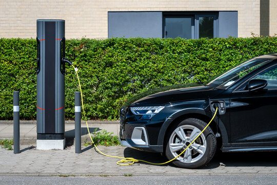 Electric vehicle with charging on a public charging station on the street in Germany