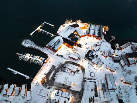 Aerial winter harbor with snow covered buildings and docks