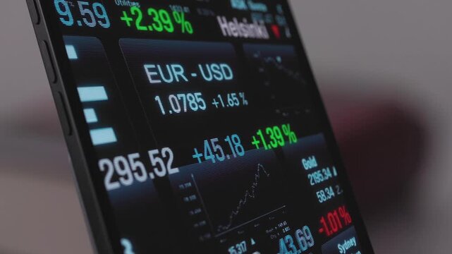 Smartphone stock market trading, ticker tape, global index information, chart and graph reflections in the display. Business, investment, equity, share price, data, financial markets. 