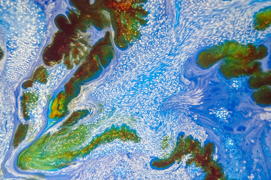 Swirling patterns of blue and green in a natural body of water near a coast