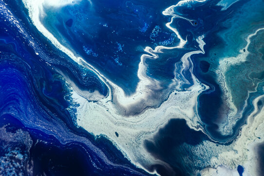 Artistic view of blue and white abstract patterns on a surface with ocean-like design