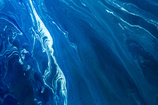 Swirls of blue colors in an abstract pattern on the surface of a body of water