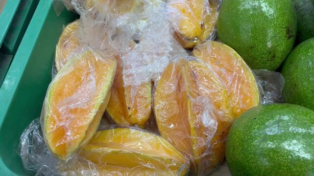 Fresh sliced ripe starfruit in plastic container package close up