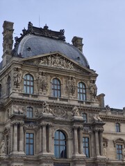 Obraz premium Sculptures and ornate facade of the Louvre Museum in Paris, France