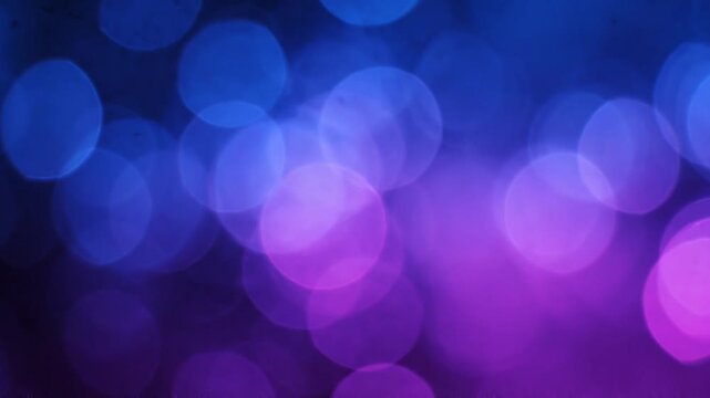 Abstract bokeh lights swirling in soft focus during a dreamy blue and purple transition with subtle motion