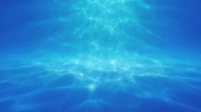 Underwater view of deep blue pool water with surface light caustics liquid texture background clear ripple
