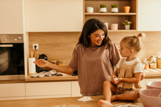 Mother and daughter bonding while baking in kitchen