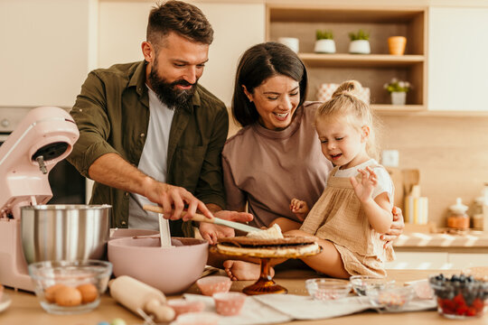 Family baking cake together in modern kitchen