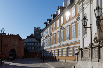 Fototapeta premium Empty cobblestone street near the historic brick barbican in Warsaw, Poland during a bright and sunny early morning.