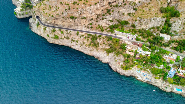 Drone footage of coastal road and tunnels along Amalfi Coast cliffs