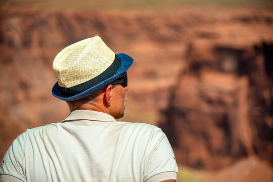 Man sitting at Horseshoe Bend admiring breathtaking canyon and river panorama view