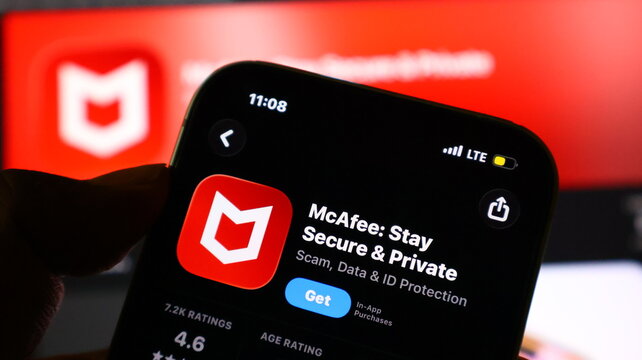 Hand holding smartphone with McAfee app on screen