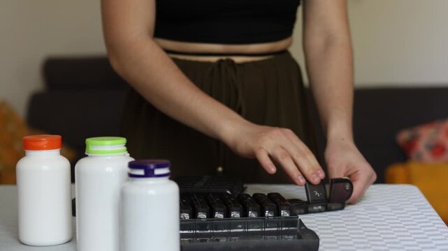 Health routine turns mechanical as person sorts pills into organizer highlighting automated habits loss of awareness and reliance on systems instead of mindful approach to personal wellbeing