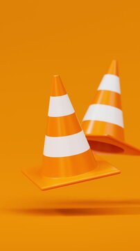 Front view pair of floating traffic cones in orange on a orange background for road safety and construction warning. Vertical video.