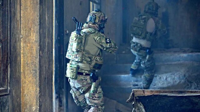 Soldier moves through damaged building in a conflict zone during day