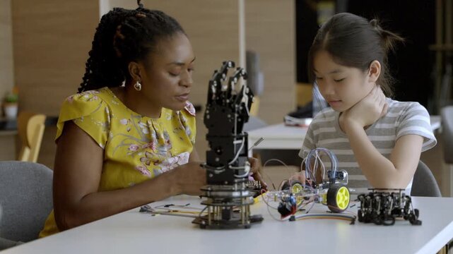 Learning robotics with a mentor in a workshop for kids during the afternoon