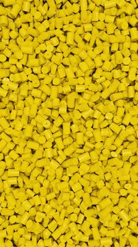 Pan across yellow polypropylene plastic granules and industrial masterbatch resin pellets, 3D render dynamic Vertical video.