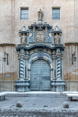 Obraz premium Baroque portal of the San Felipe y Santiago el Menor Church in Zaragoza. Ornate stone entrance with twisted columns and religious statues in the historic center. Zaragoza, Spain - November 29, 2021
