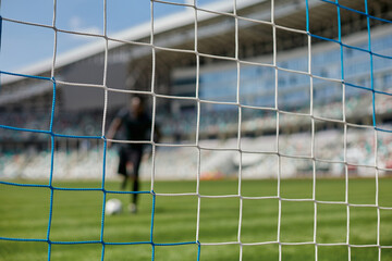 Young african american man holding soccer ball against soccer goal net © Katsiaryna