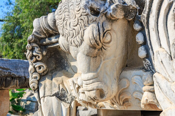 Obraz premium Ancient stone bull sculpture with intricate details in outdoor setting