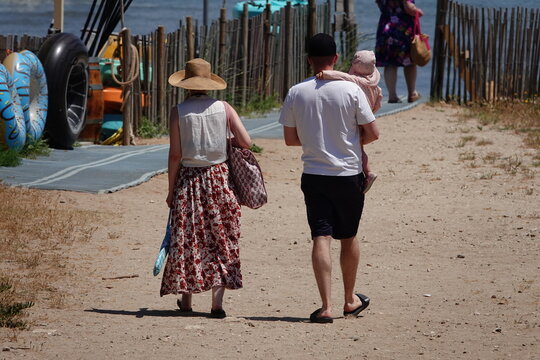 Famille en vacances allant &agrave; la plage par un chemin de sable