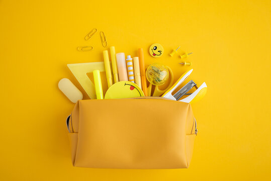 School supplies spilling from yellow pencil case