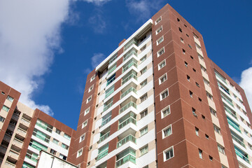 Fototapeta premium High-Rise Residential Building with Brick Facade and Modern Balconies