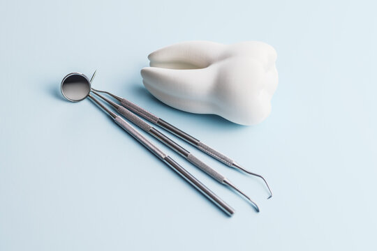 Dental Tools and Tooth Model on Blue Background for Oral Care and Dental Clinic Use