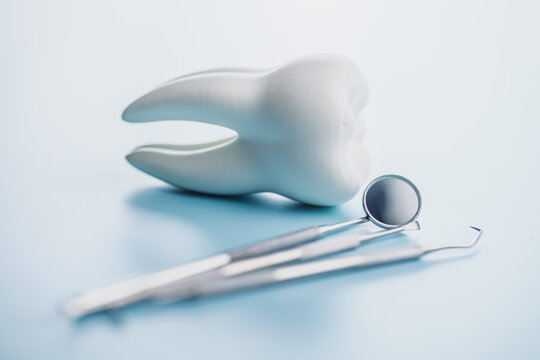 Dental Tools and Tooth Model on Blue Background for Oral Care and Dental Clinic Use
