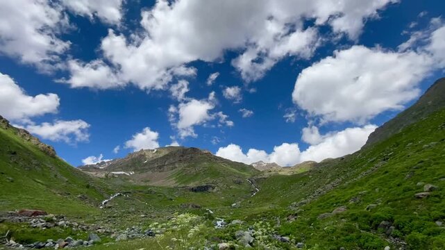 Dramatic 4K time-lapse of fast-moving white clouds passing over a deep mountain valley and blue sky in Anatolia
