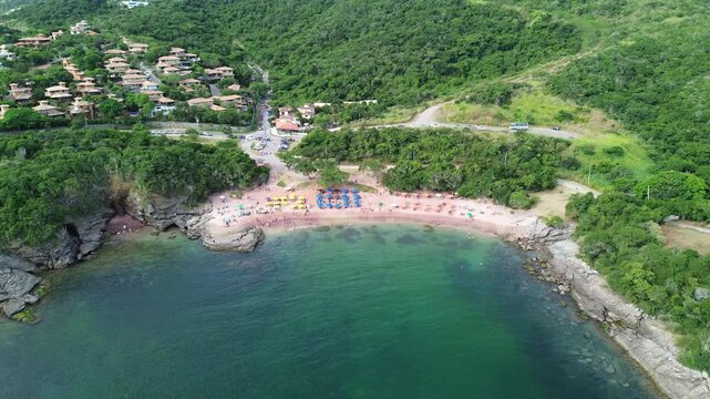 Smooth aerial drone footage approaching Praia do Forno, highlighting its crystal-clear turquoise waters