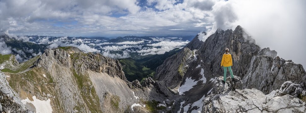 Alpine panorama, hiker on a summit, Westliche T&ouml;rlspitze, mountains in dramatic clouds, Wetterstein Mountains, Garmisch-Partenkirchen, Bavaria, Germany