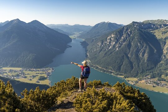 Young hiker, woman looking into the distance, view from B&auml;renkopf mountain to Lake Achen, left Seebergspitze and Seekarspitze, right Rofan Mountains, Tyrol, Austria