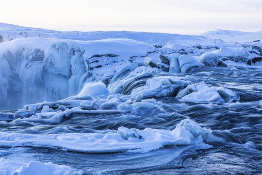Icefall at the edge of the Godafoss waterfall at dawn, snow-covered landscape, Northern Iceland Eyestra, Iceland