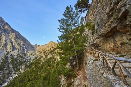 Stony hiking trail along a rock face, surrounded by mountains and trees, Xyloskalo, wooden staircase at the entrance to the Samaria Gorge, Lefka Ori, White Mountains, mountain massif, west, Crete, Greece