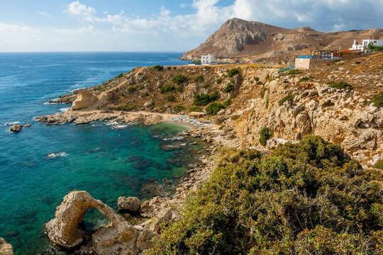 Panoramic view of rocky coastline with natural sea arch and turquoise bay on Rhodes Island, Greece
